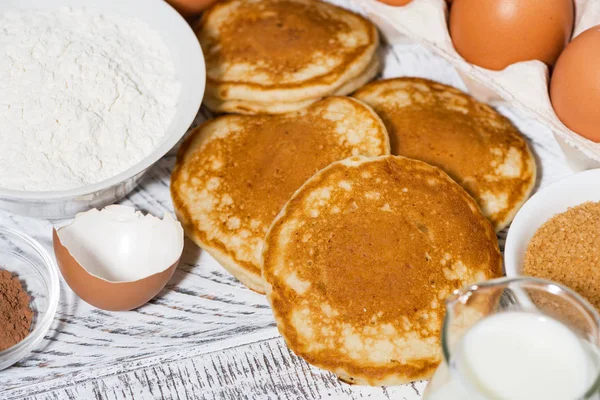 Ingrédients pour faire cuire des crêpes sur une table en bois blanc, gros plan — Photo