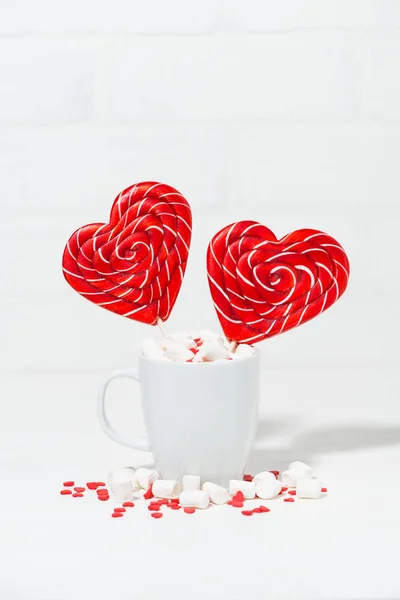 Caramelo en un palo en forma de corazón en una taza de malvaviscos —  Fotos de Stock