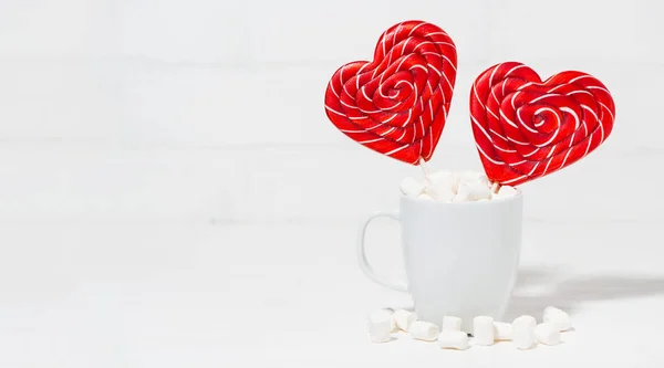 Candy on a stick in the form of hearts in a white cup — Stock Photo, Image