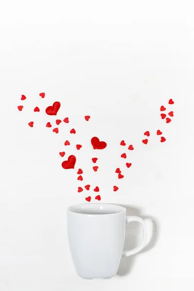 Cukrová srdíčka a bílý pohár, koncept fotografie na Valentýna — Stock fotografie