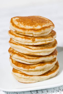 Beyaz tabakta bir yığın leziz krep, dikey