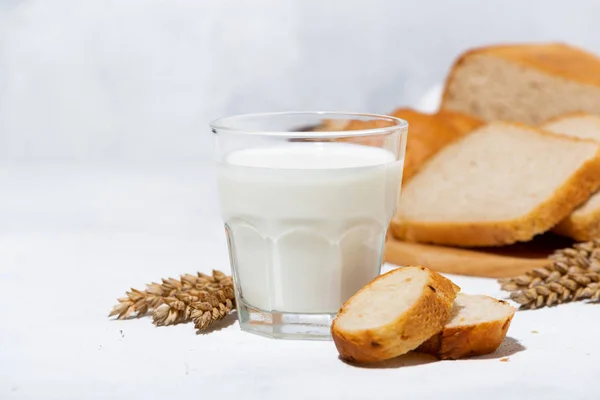 Glass of milk, assortment of fresh bread and ingredients — Stock Photo, Image