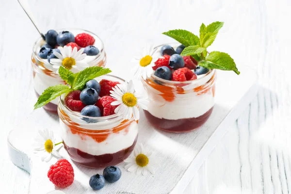 Sobremesa com engarrafamento, nata e fruto fresco em jarros de vidro — Fotografia de Stock