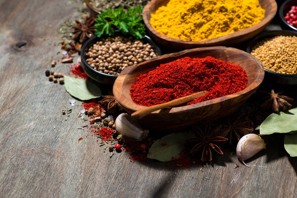 assortment of spices and herbs on a wooden table