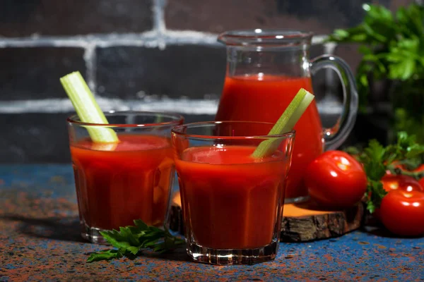 Färsk tomatjuice med selleri i glas på bordet — Stockfoto