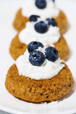 Kremalı ve yaban mersinli balkabağı kekleri, yakın plan.