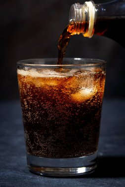 Coca Cola şişeden bardağa doldurulur, yakın plan.