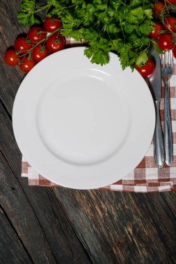 Masa seti beyaz tabak ve sebzeler ahşap arka planda, üst manzara