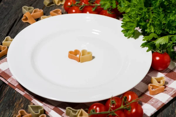 Mesa Con Plato Blanco Pasta Verduras Sobre Fondo Madera Primer —  Fotos de Stock