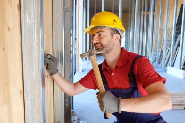 Carpintero usando martillo en un sitio de construcción — Foto de Stock