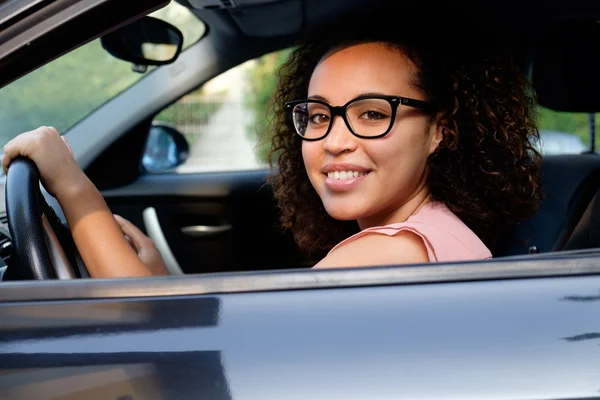 Счастливая молодая женщина, сидящая в новой машине — стоковое фото