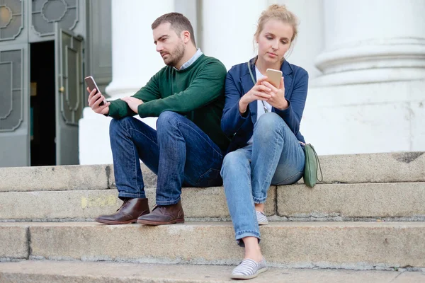 Um casal conversando com seu smartphone — Fotografia de Stock