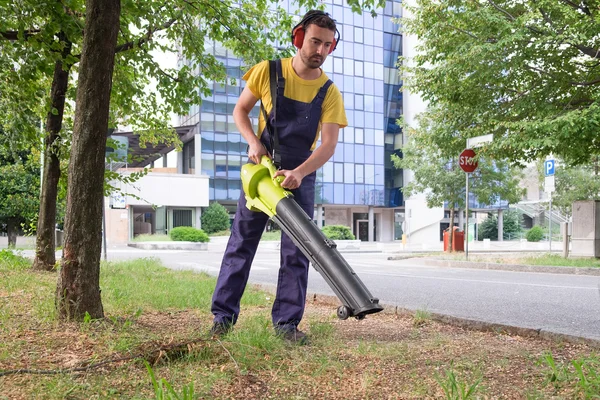 Jardineiro usando seu ventilador das folhas no jardim — Fotografia de Stock