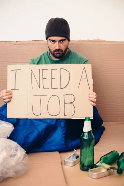 Homeless seated in the street and asking for a job — Stock Photo, Image