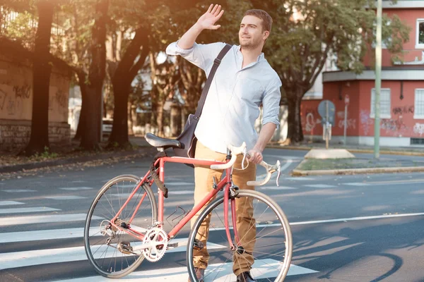 Hombre de moda sosteniendo su bicicleta en la calle de la ciudad — Foto de Stock