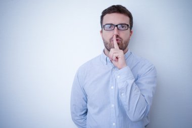 Man asking for silence using finger gesture clipart