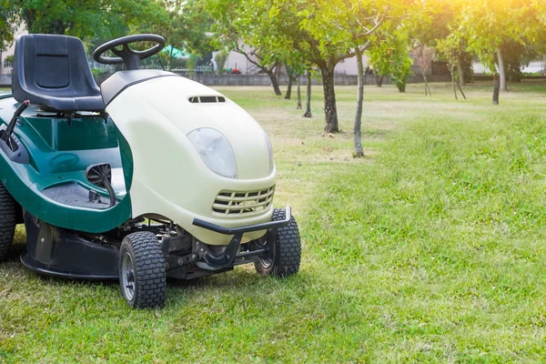 Grasmaaier geparkeerd in een tuin — Stockfoto