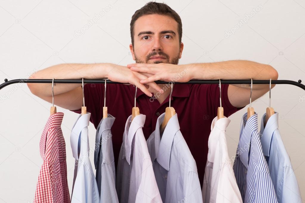 Man choosing shirts in several colors and textures