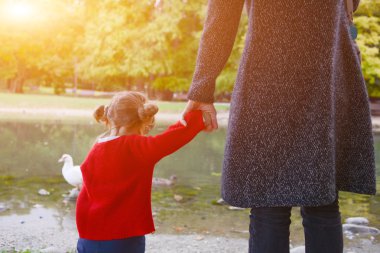 Genç bebek el ele parkta annesiyle yürüyüş