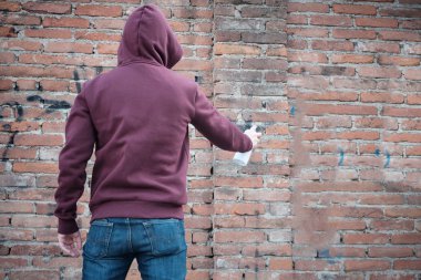 Kukuletalı tagger kentsel duvarlarda grafiti yazma