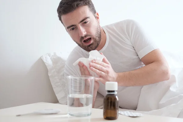 Man gevoel koude, liggend in het bed en niezen — Stockfoto