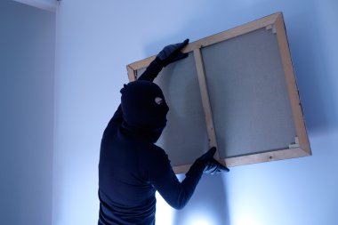 Hırsız çalmak bir boyama duvar ev içinde