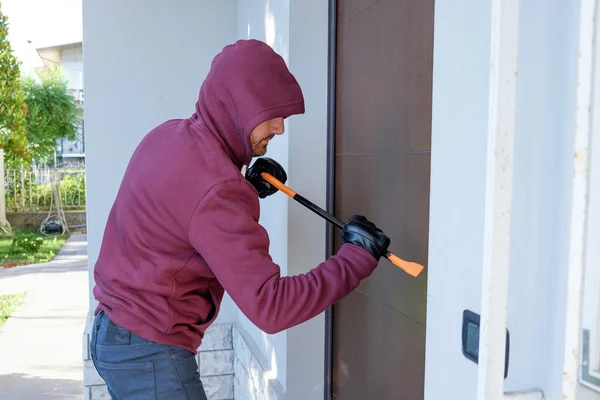 Inbrottstjuv försöker tvinga en dörr låsa med hjälp av en kofot — Stockfoto
