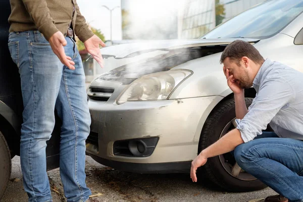 Kaksi miestä riitelee auto-onnettomuuden jälkeen. — kuvapankkivalokuva