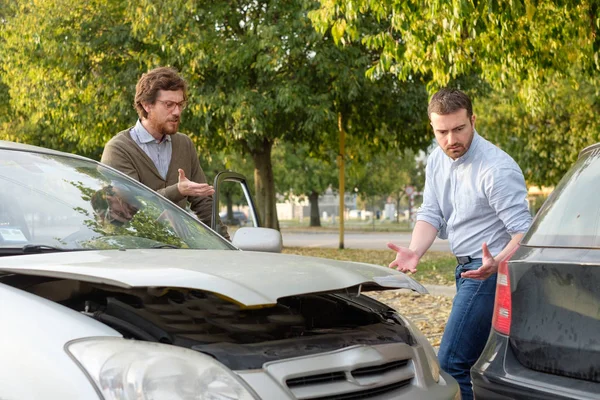 Two men arguing after a car accident on the road — Stock Photo, Image