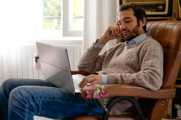 Uomo che lavora a casa con il suo computer portatile e connessione internet wi-fi — Foto Stock