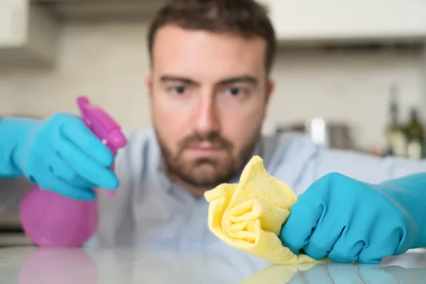 Hombre limpiando casa con guantes protectores — Foto de Stock