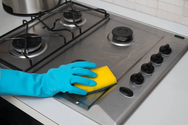 Woman cleaning stainless steel gas surface in  the kitchen at ho — Stock Photo, Image