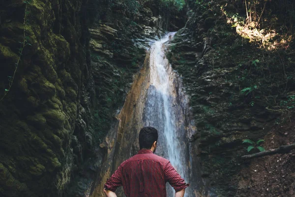 Mann nach Bergwanderung neben einem Wasserfall — Stockfoto