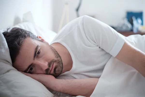 Depressiver Mann liegt in seinem Bett und fühlt sich schlecht — Stockfoto