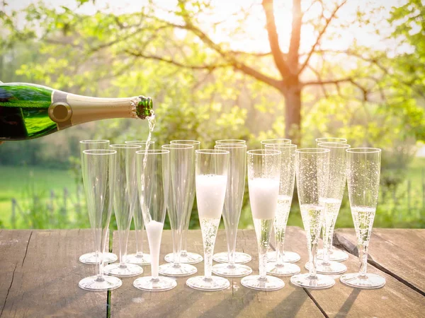Mano versando vino in bicchieri di flauto di champagne — Foto Stock