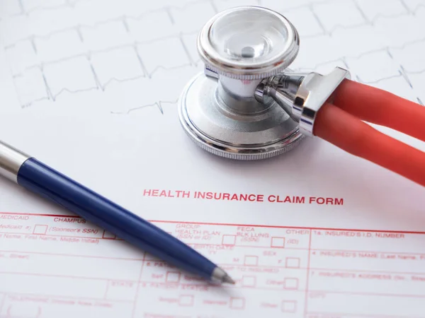 Health insurance claim form with pen and stethoscope — Stock Photo, Image