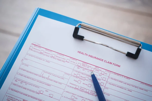Formulário de reclamação de seguro de saúde com caneta — Fotografia de Stock