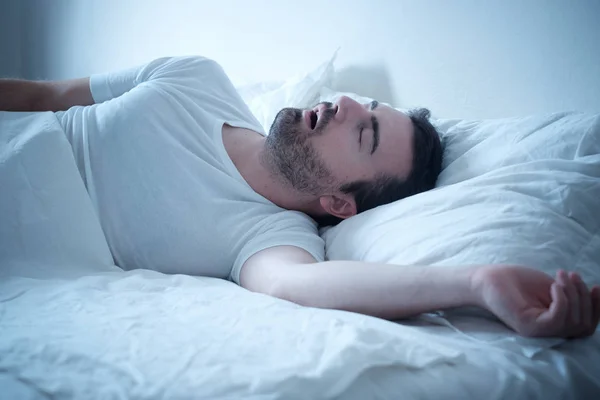 Mann schläft in seinem Bett und schnarcht laut — Stockfoto