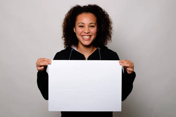 Μαύρη γυναίκα εμφανίζει λευκό πανό που απομονώνονται σε φόντο — Φωτογραφία Αρχείου