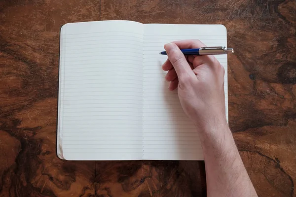 Escritura a mano en una nota de papel sobre una mesa de madera — Foto de Stock