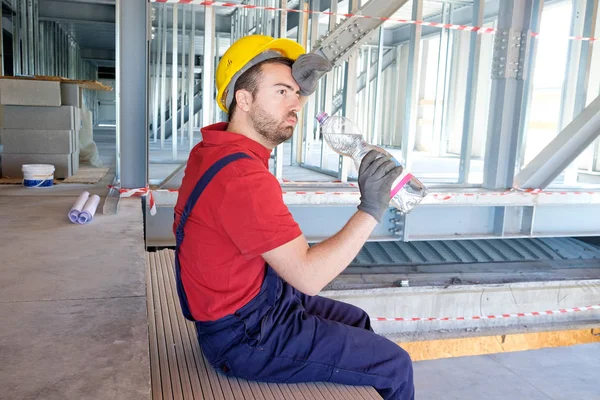 Trabalhador cansado no canteiro de obras está tendo uma pausa — Fotografia de Stock