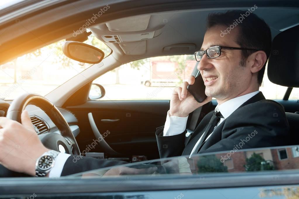 Manager calling on the phone seated in the car portrait