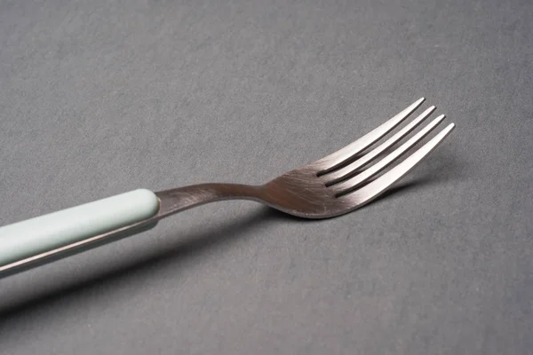 Natura morta di una forchetta su sfondo grigio — Foto Stock