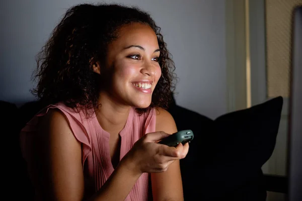 Молода жінка дивиться телевізор вночі — стокове фото