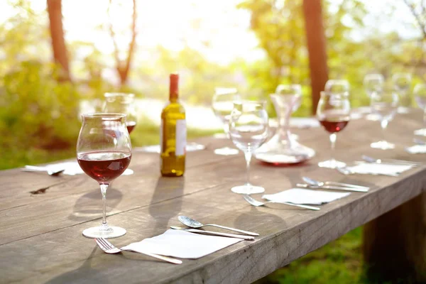 Copas de vino en una mesa de madera en el campo poca profundidad — Foto de Stock