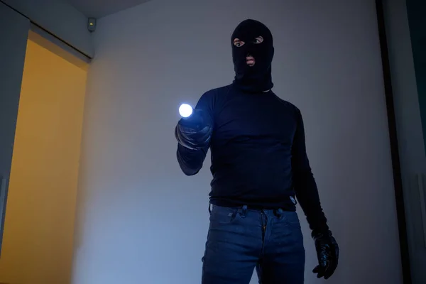 Inbreker het dragen van een balaclava houden een zaklamp — Stockfoto