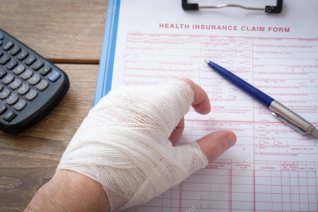 Injured hand filling a insurance claim form