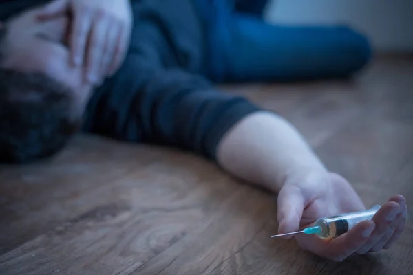 Muž ležel na podlaze po předávkování drogami — Stock fotografie