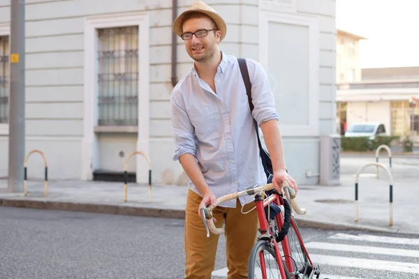 Модний чоловік тримає свій велосипед на міській вулиці — стокове фото