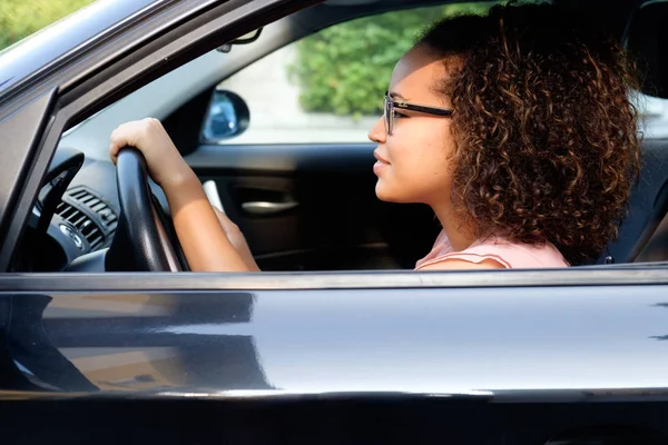 Joyeux jeune femme assise dans sa nouvelle voiture — Photo